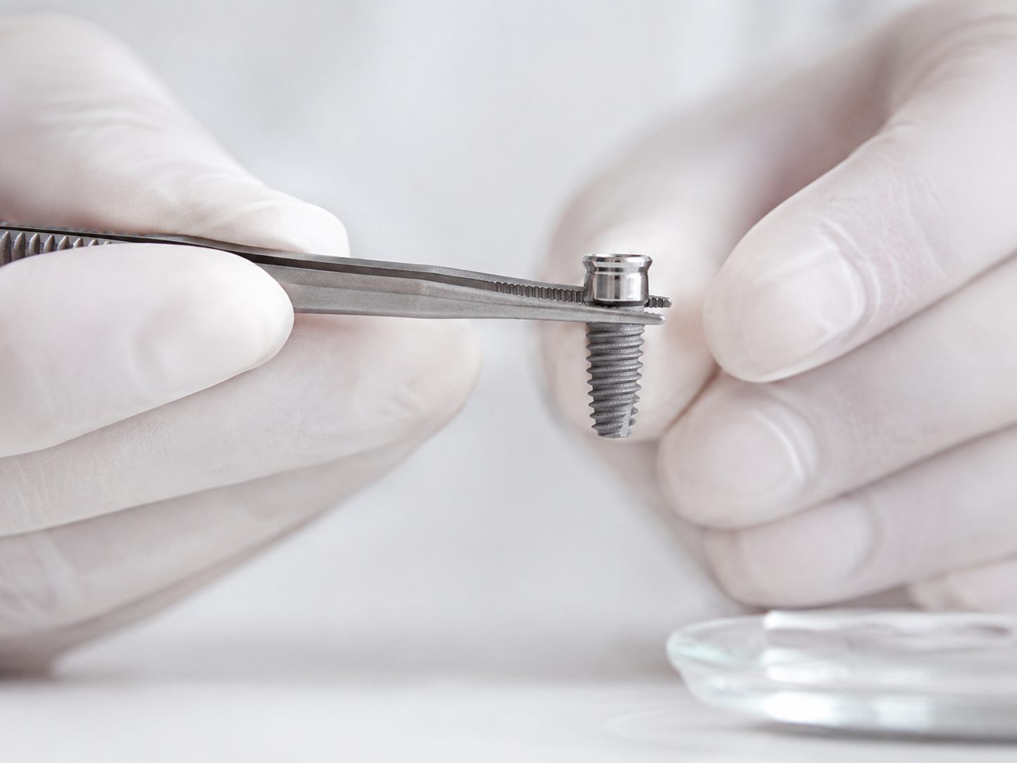 Operating faculty supervising a trainee dentist during live implant placement